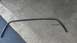 1996 Ford Bronco - A detached rubber seal, likely for a car window, lies on a concrete surface.