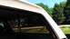1996 Ford Bronco - Looking out the side window of a vehicle at a residential area with trees and a street visible.