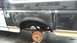 1996 Ford Bronco - The rear wheel well of a Ford Bronco shows signs of body repair and rust, with the drum brake visible.