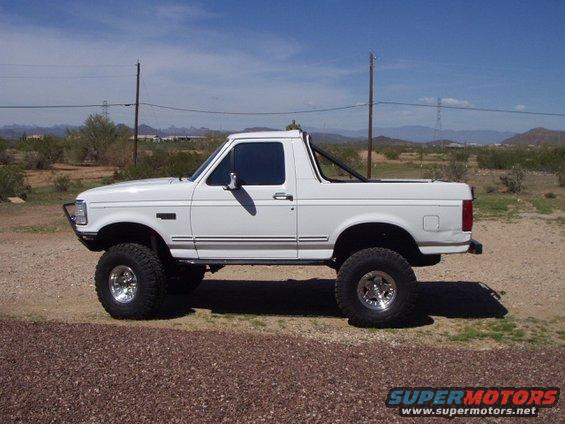 White 1993 Ford Bronco lifted with off-road tires, side view