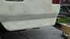 1996 Ford Bronco - The rear section of a vehicle is shown with body filler applied, indicating preparation for repair or painting.
