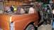 1996 Ford Bronco - An orange SUV is shown with its doors removed, undergoing work in a garage.