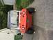 1986 Argo Response - This orange amphibious ATV is parked on a gravel surface next to a building and a green trash bin.