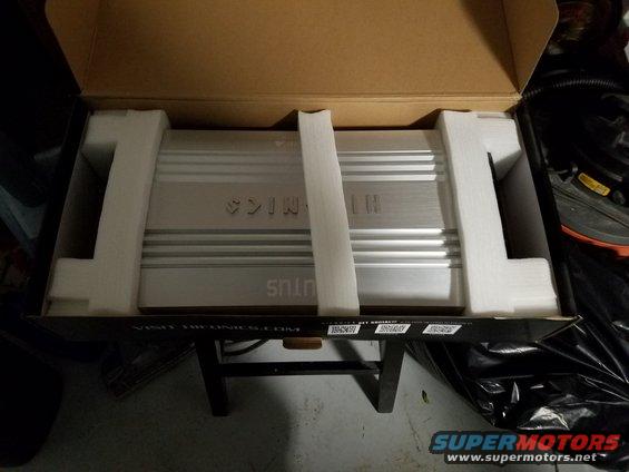 Car amplifier in box with foam padding. Text on amplifier reads 'SINUS' and 'LH'. Website 'VISIT HTRONICS.COM' visible on box