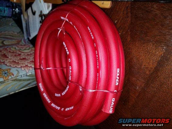 Coiled red 0 gauge power wire with white text reading 'SOUND' and 'POWER WIRE'