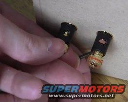 Two gold-plated audio connectors, one held by a hand