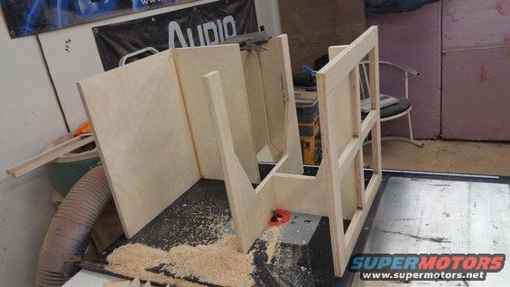 Wooden speaker enclosure parts on a table saw with sawdust