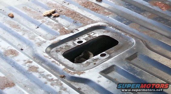 Corrugated metal truck bed with recessed area and debris. Supermotors.net logo visible