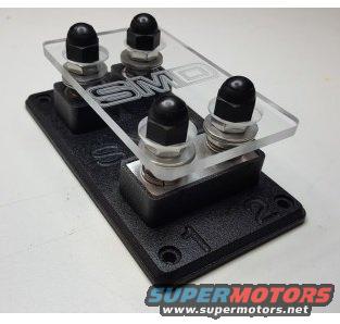 SMD stereo part with clear top and four black nuts on a black base
