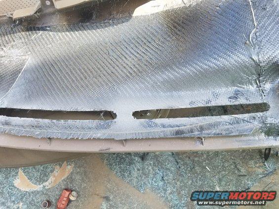Carbon fiber dashboard with cutouts for vents, undergoing repair