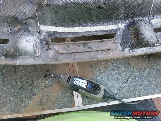 Dashboard section with carbon fiber texture and air vents, being cut with a Dremel tool