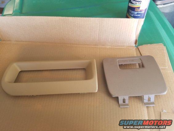 Tan dashboard trim piece and a small cover panel, possibly for a radio or storage compartment