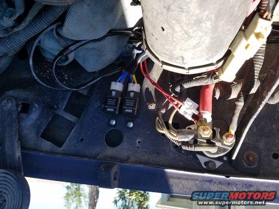 Headlight relays and wiring harness under a vehicle