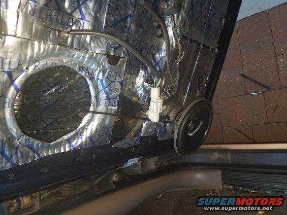 Car door panel removed showing sound deadening material and speaker wiring