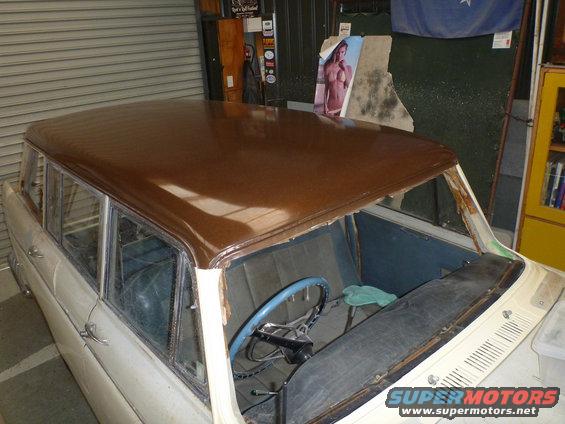 Station wagon interior with blue seats and a brown roof. Steering wheel is blue