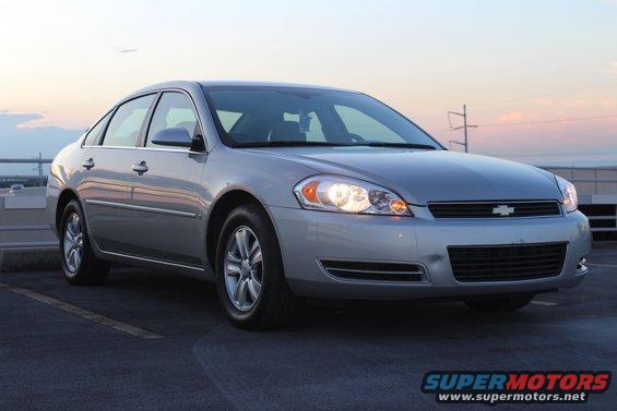 Silver Chevrolet sedan parked on asphalt, front quarter view