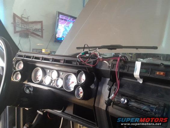 Dashboard with multiple aftermarket gauges and a Sony stereo, wires exposed