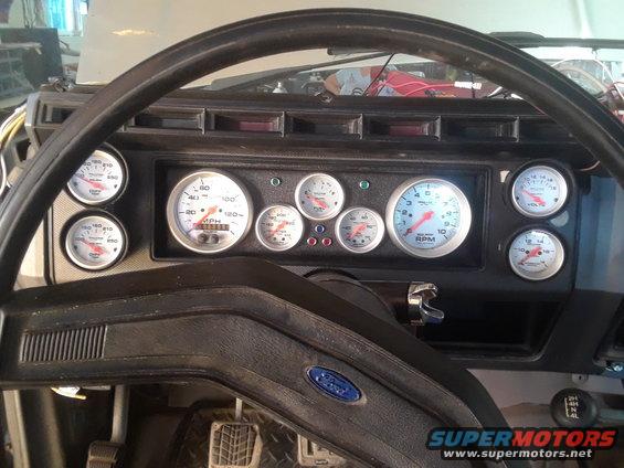 Dashboard with aftermarket gauges including speedometer, tachometer, oil pressure, and voltage