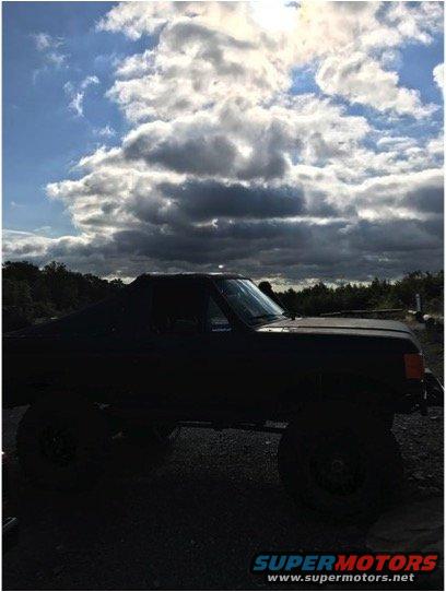 Black 1989 Ford Bronco parked outside under a cloudy sky