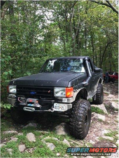 1989 Ford Bronco with snorkel and winch on rocky trail. Another vehicle visible in background