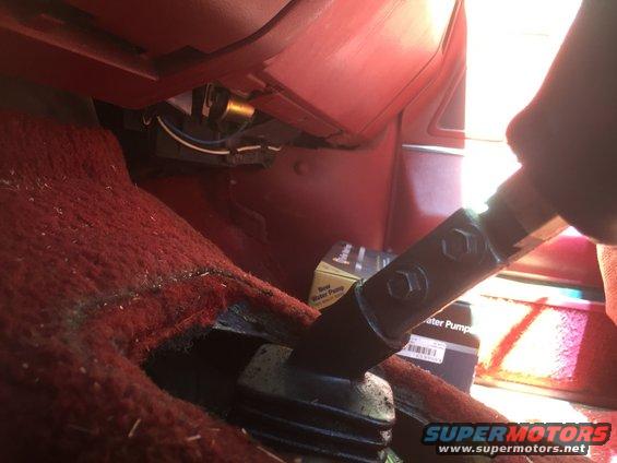 Interior view of a vehicle's manual shifter and a box for a new water pump