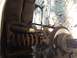 1986 Ford Bronco - This image shows the front suspension and brake assembly of a vehicle, with a wrench positioned near the coil spring.