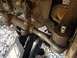 1986 Ford Bronco - Vehicle steering linkage components are visible, supported by a jack.