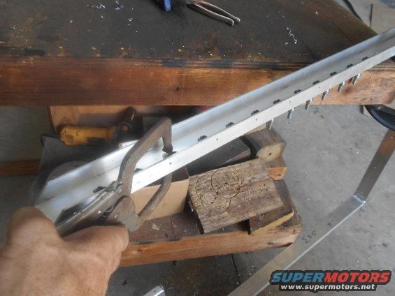 Aluminum channel with holes drilled, held by clamp