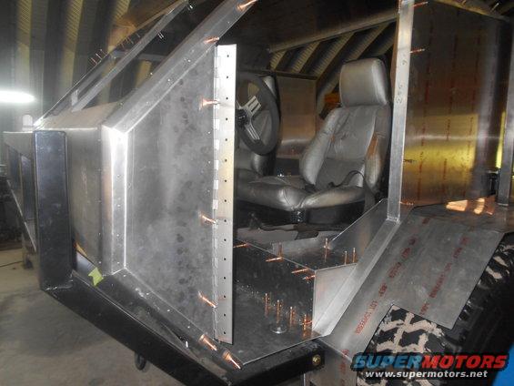 Interior of a custom vehicle build with metal paneling and seats visible