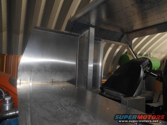 Interior view of custom metal fabrication inside a vehicle, showing a seat and dashboard area