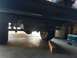 1988 Ford Bronco - Underside view of a vehicle's rear axle and tires, showing suspension components and tow hitch receiver.
