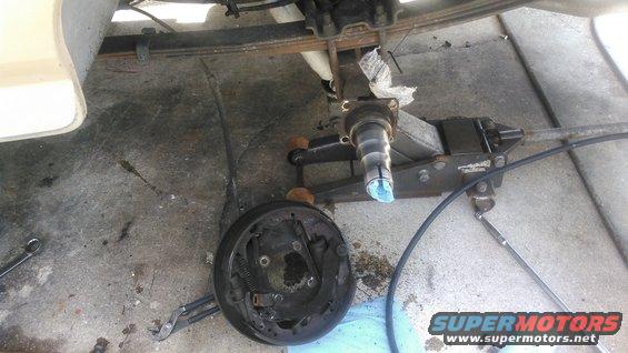 kimg0070.jpg take off the 4 bolts holding the brake backing plate off. disconnect the brake line. the backing plat should come off pretty easy

be prepared to have a way to stop the brake fluid once the line is disconnected. i used a plastic bag and a ziptie to slow it down best i could.

you can remove the e-brake cable whenever you feel. 