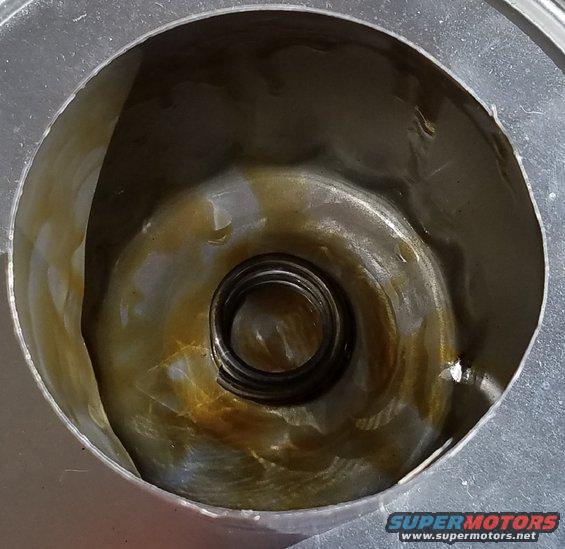 Inside of an oil filter housing with a spring and some oil residue