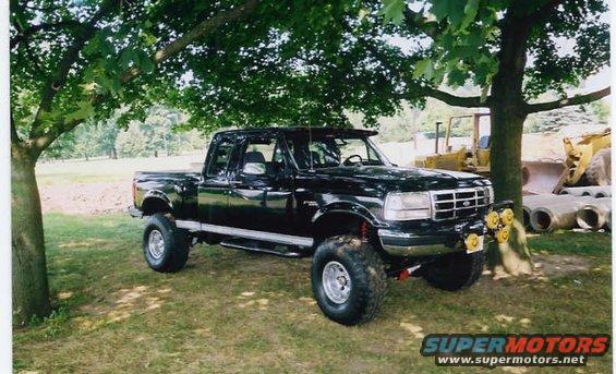 Black 1994 Ford F-150 pickup truck parked under trees