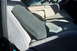 1995 Ford Bronco - The interior of a vehicle shows the front seats and a center console with an armrest.