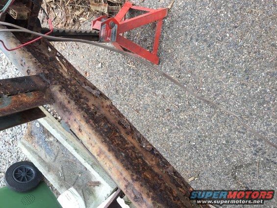 Rusted trailer frame section with red jack stand
