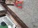 1986 Argo Response - A close-up view of a heavily rusted trailer frame, supported by a red jack stand.