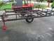 1986 Argo Response - A utility trailer frame is shown, supported by jack stands, with a red amphibious vehicle behind it.