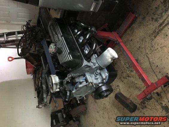 Engine on a red engine stand, looks like a Ford V8