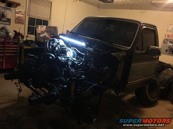 Ford truck with engine removed, viewed from the front in a garage