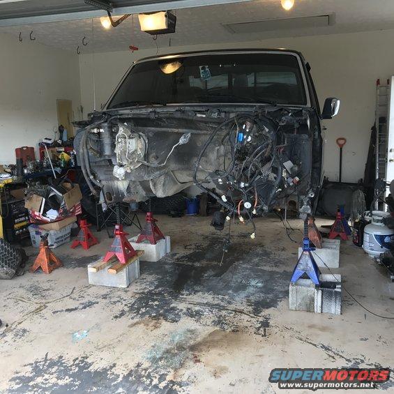 1995 Ford F-150 front end removed, truck raised on jack stands in garage