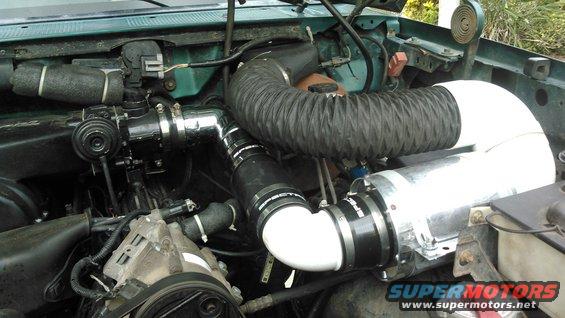 the outlet finished going to the engine.

because of my aftermarket mustang style intake, this is how i needed to run my intake. my MAF sensor i have pointed downwards in order the the connector to reach.

i used a 3inch sewer (3034,not sch40) 90* elbow along with a  4x3.5 Spectre coupling to go from the housing to the elbow, then a 3.5 coupling to go to my Pro-M bullet unflanged 75mm MAF sensor. i used some assorted 3inch Spectre piping to connect to the 75mm throttle body