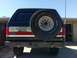 1988 Ford Bronco - The rear of a Ford Bronco shows a spare tire mounted on the tailgate and an aftermarket bumper.