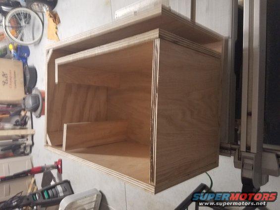 Wooden enclosure with multiple compartments, viewed from a slight angle