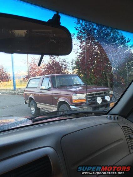 Maroon SUV with off-road lights, 3q-front view. Appears to be a 1992 Ford Bronco