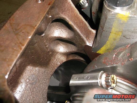 Close-up of cast iron engine block with oil residue and yellow paint markings