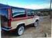 1987 Ford Bronco II - This 1987 Ford Bronco II is parked outdoors with a desert-like landscape and mountains in the distance.