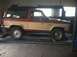 1987 Ford Bronco II - Side view of a 1987 Ford Bronco II in a garage, positioned on a lift.