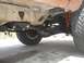 1987 Ford Bronco II - Close-up view of the underbody and suspension of an off-road vehicle, showing the frame and drivetrain components.