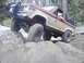 1987 Ford Bronco II - A 1987 Ford Bronco II navigates a challenging rocky terrain with its front-left wheel high in the air.